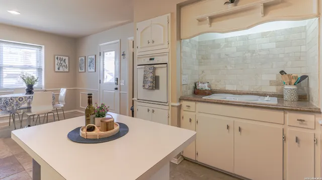 a kitchen with a sink a table and chairs