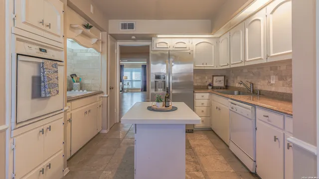 a kitchen with stainless steel appliances granite countertop a sink and cabinets