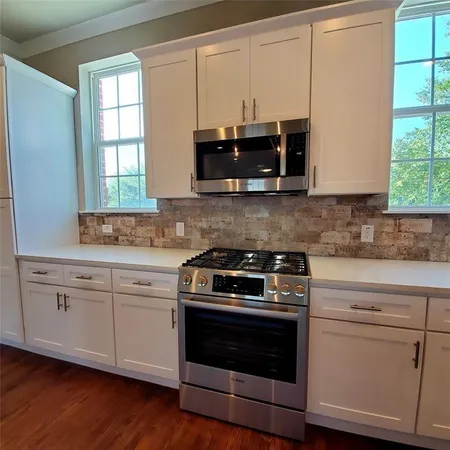 a kitchen with cabinets appliances and a window