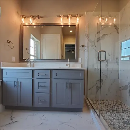 a bathroom with a sink a vanity a mirror and a shower