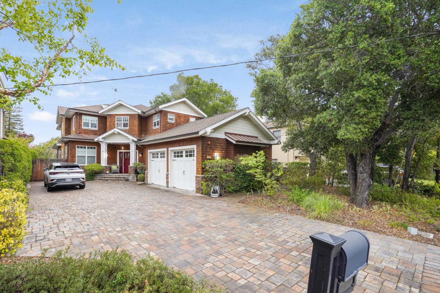 a front view of a house with a garden and trees