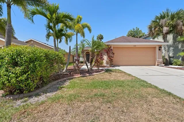 a view of a house with a yard and potted plants