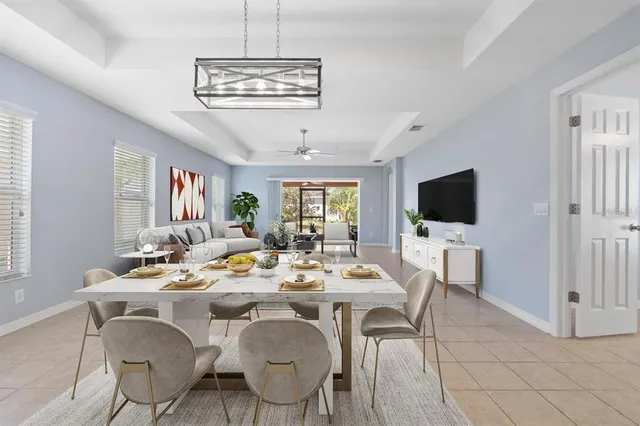 a dining room with wooden floor a chandelier a glass table and chairs