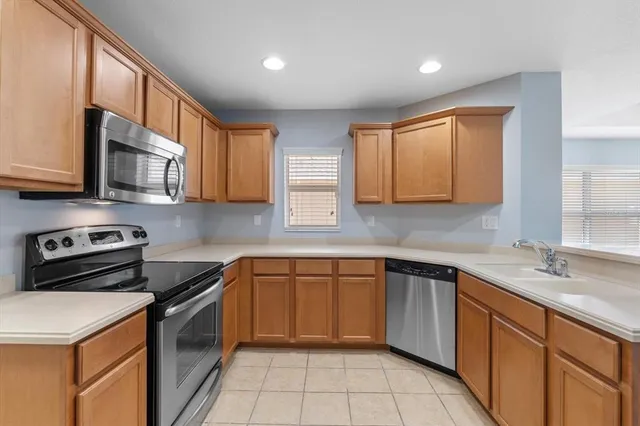 a kitchen with stainless steel appliances granite countertop a sink stove and cabinets