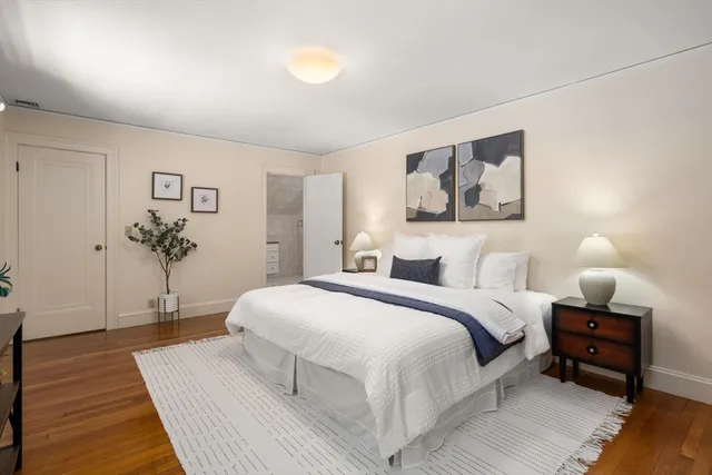 a bedroom with a large bed and a wooden floor