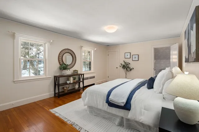 a bedroom with a bed a mirror and a window