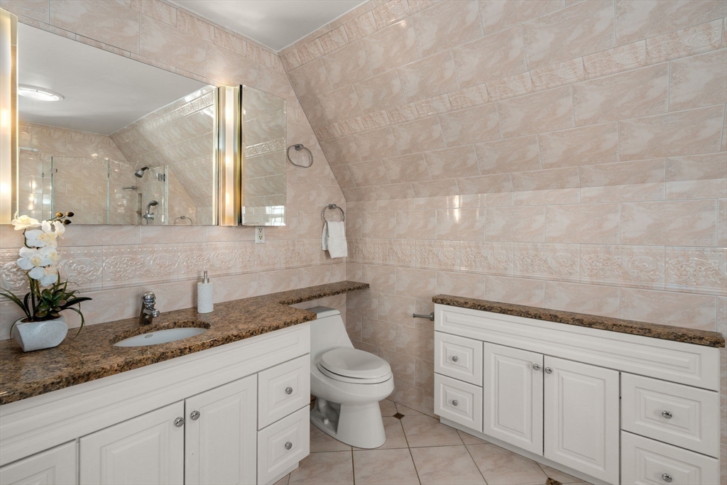 36 Goodnough Road Brookline, MA 02467 - Photo 20 of 31 a bathroom with a granite countertop sink a toilet and a mirror