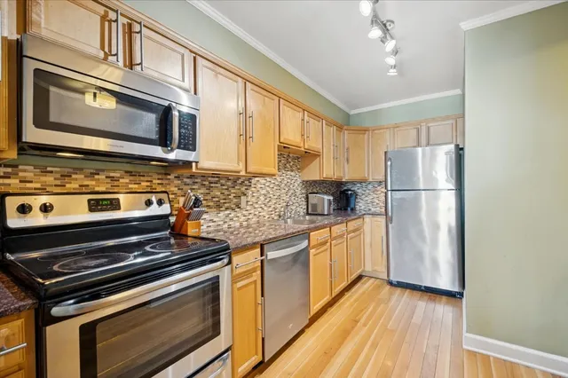 a kitchen with stainless steel appliances granite countertop a refrigerator stove and sink