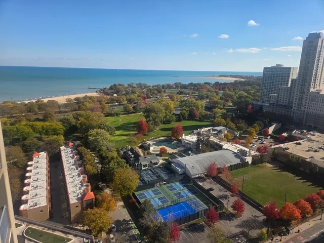 an aerial view of a city with lots of residential buildings ocean and mountain view in back