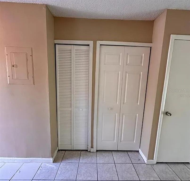 5869 Curry Ford Road Orlando, FL 32822 - Photo 7 of 10 an empty room with wooden floor and mirror