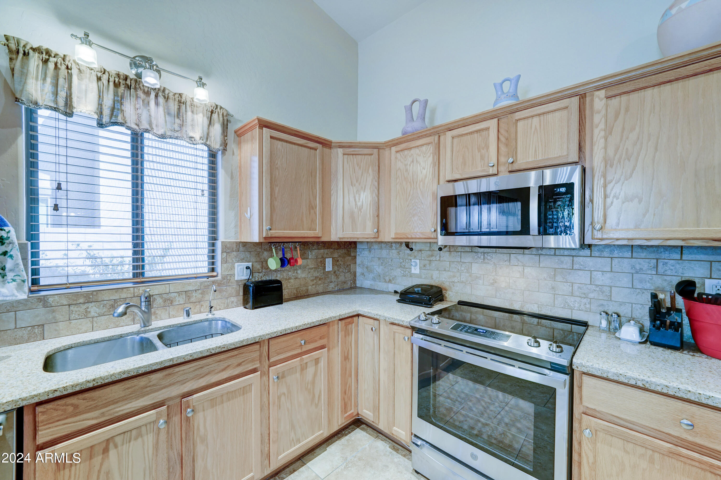 2101 South Meridian Road, Unit 126 Apache Junction, AZ 85120 - Photo 12 of 58 a kitchen with granite countertop a sink a stove and cabinets