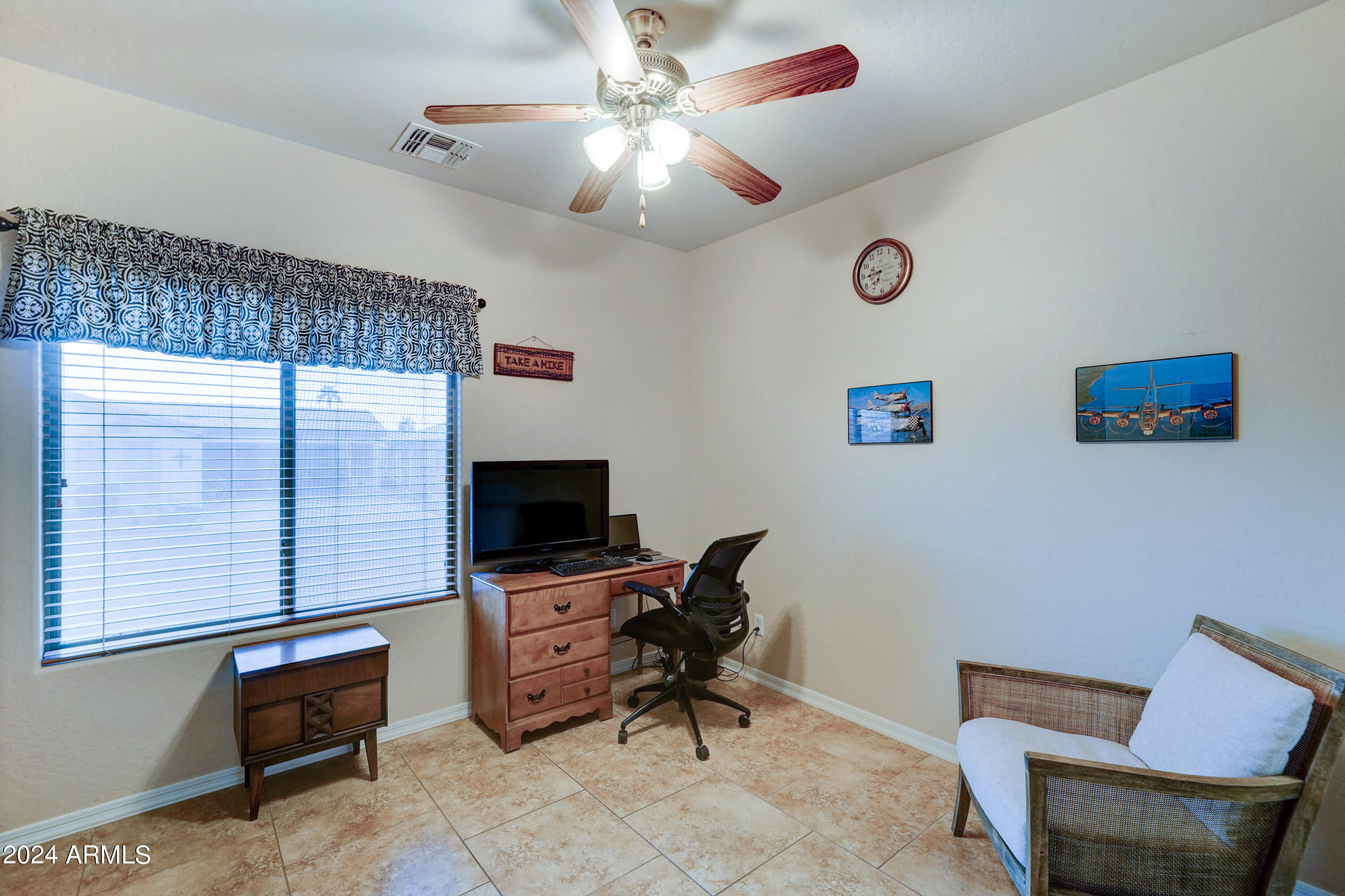 2101 South Meridian Road, Unit 126 Apache Junction, AZ 85120 - Photo 13 of 58 a livingroom with lounge chair and a ceiling fan