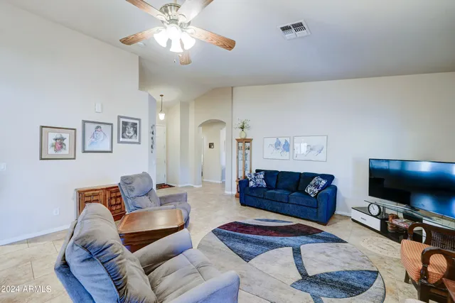 a living room with furniture kitchen view and a flat screen tv