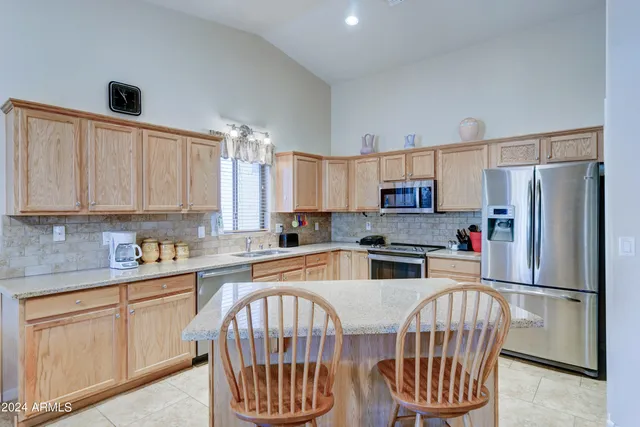 a kitchen with kitchen island a stove a sink a refrigerator and a refrigerator