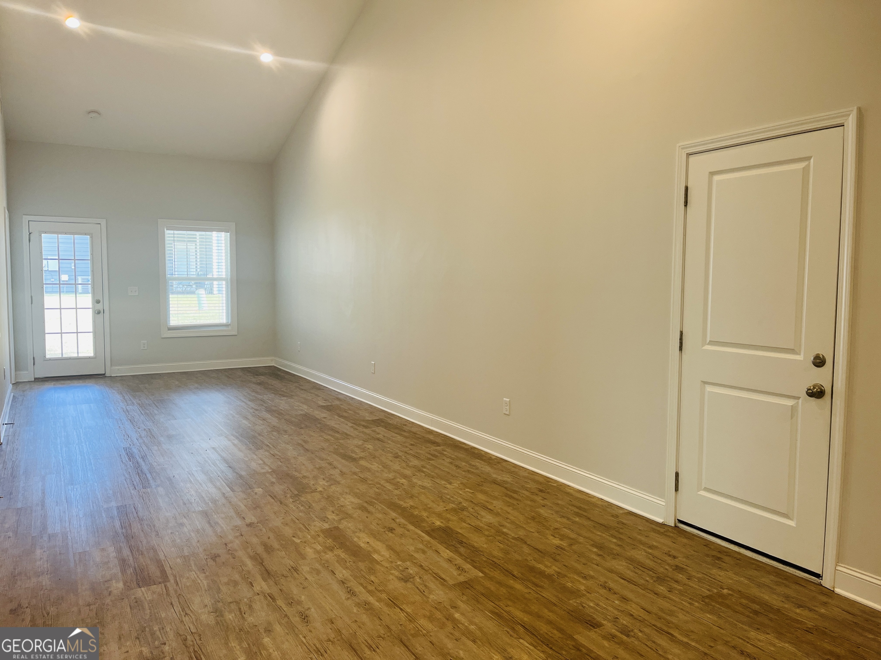 110 Lenox Circle LaGrange, GA 30241 - Photo 9 of 23 an empty room with wooden floor and windows
