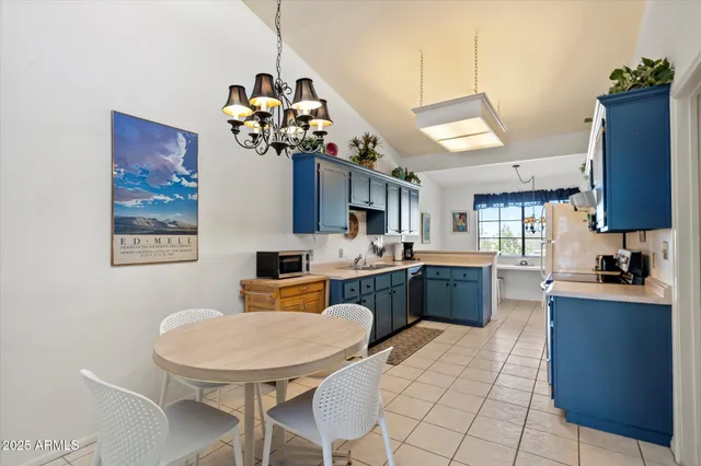 a kitchen with a table chairs sink and cabinets