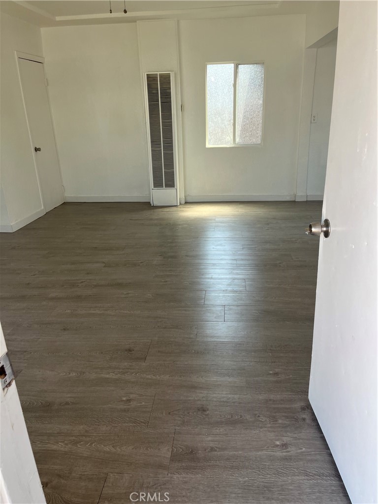 9325 East 8th Street, Unit A Rancho Cucamonga, CA 91730 - Photo 5 of 5 a view of an empty room with wooden floor and a window