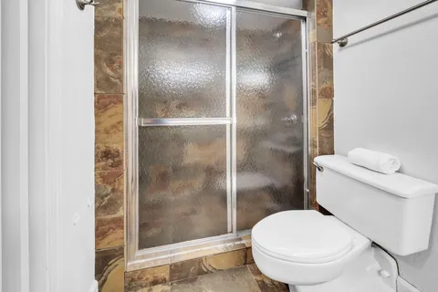 a white toilet next to a bathroom