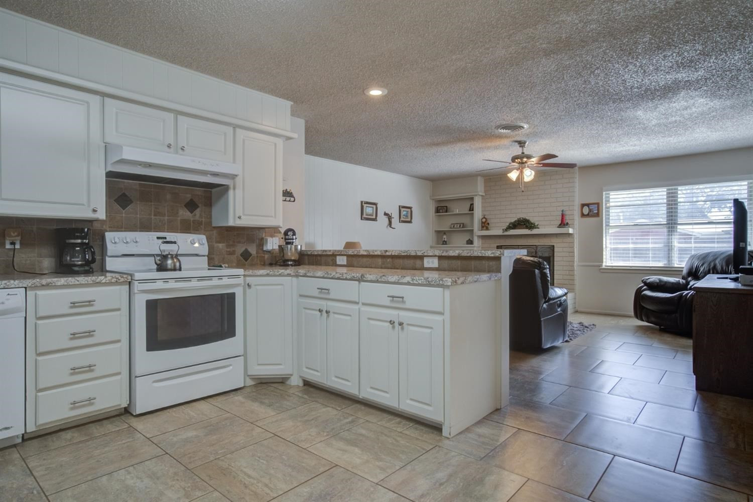 5427 46th Street Lubbock, TX 79414 - Photo 14 of 38 a kitchen with a white cabinets and appliances