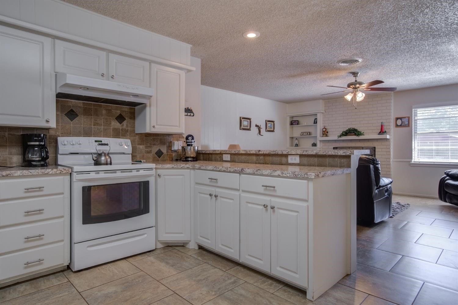 5427 46th Street Lubbock, TX 79414 - Photo 16 of 38 a kitchen with a white cabinets and stove top oven
