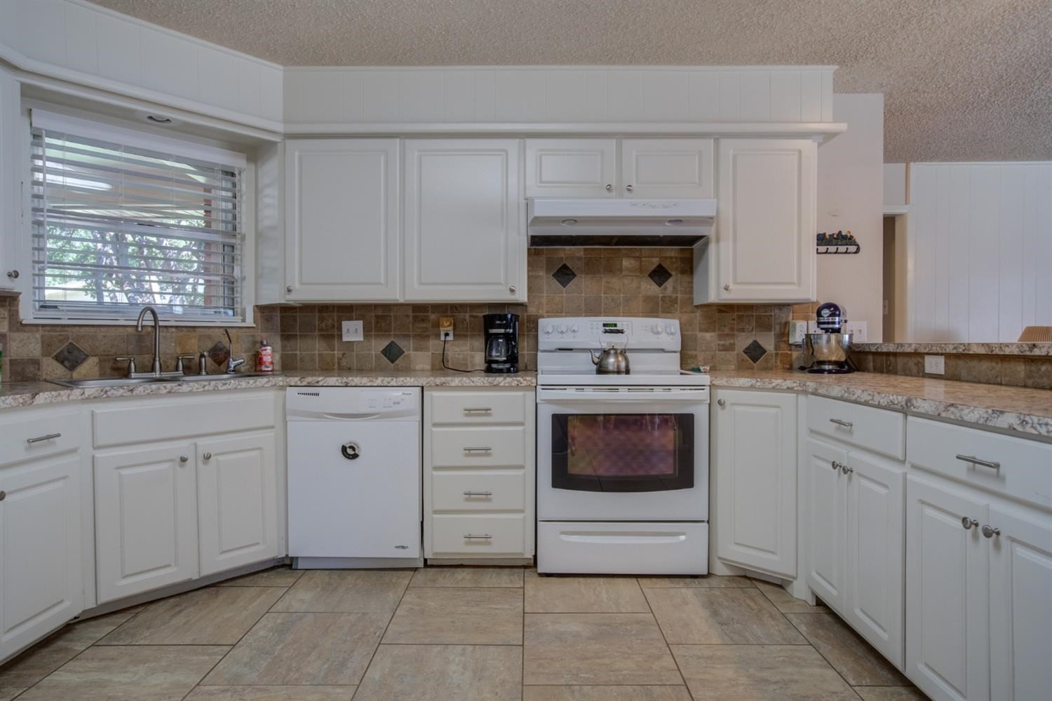 5427 46th Street Lubbock, TX 79414 - Photo 17 of 38 a kitchen with cabinets appliances a sink and a window