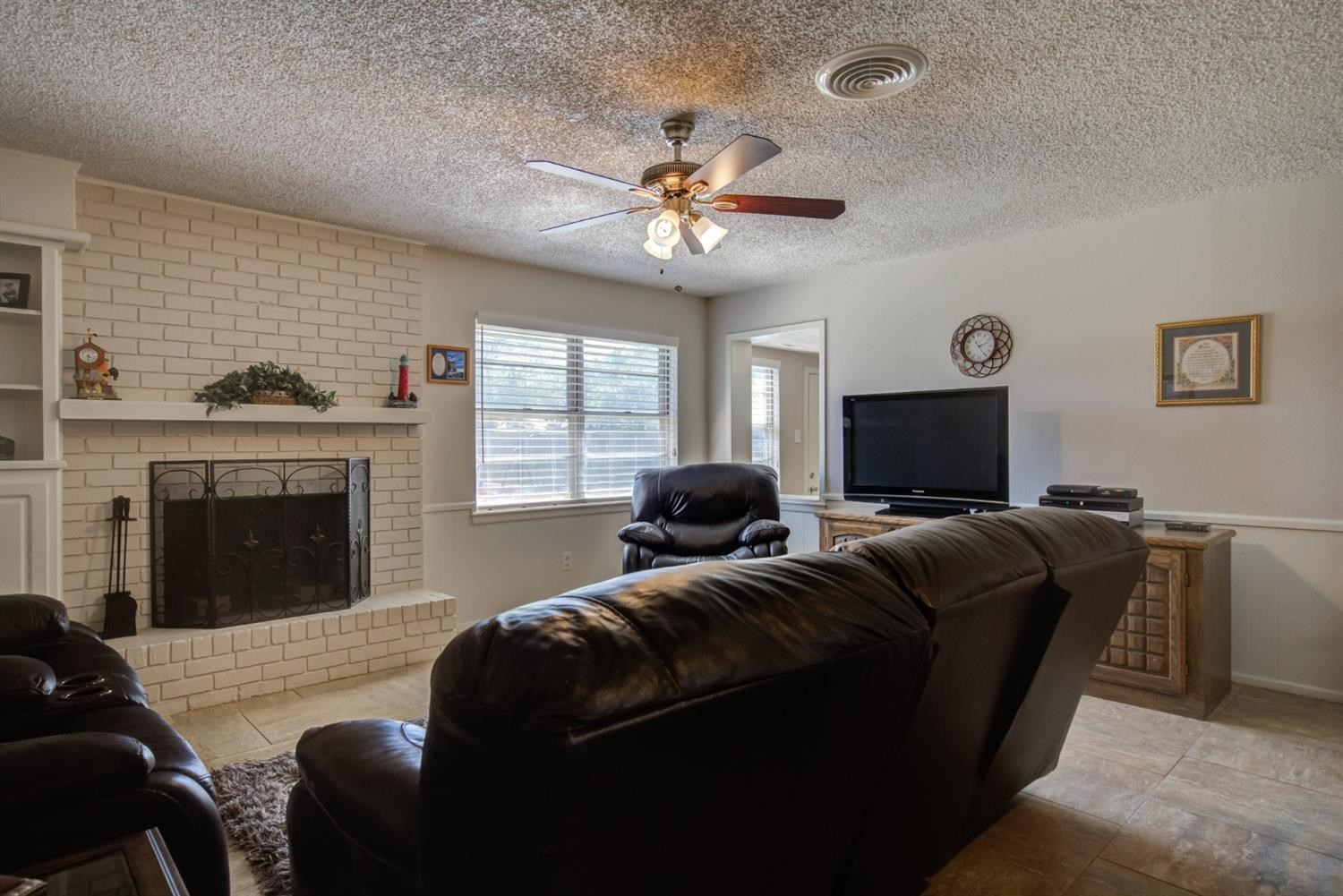 5427 46th Street Lubbock, TX 79414 - Photo 7 of 38 a living room with furniture a fireplace and a flat screen tv