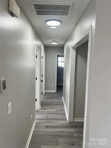 a view of a hallway with wooden floor