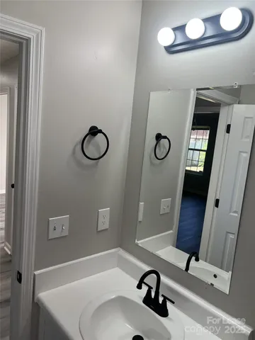 a bathroom with a granite countertop sink a mirror and a vanity