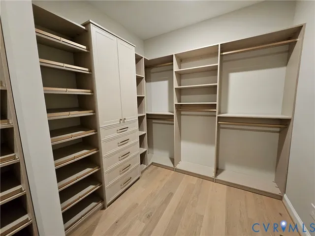 a view of walk in closet with empty racks