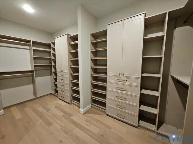 a view of walk in closet with empty racks