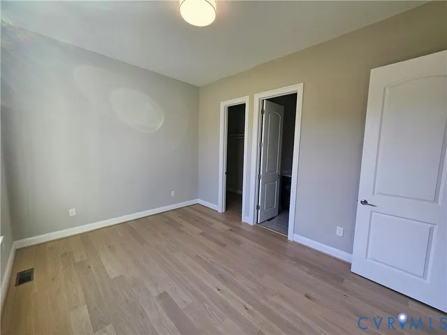 an empty room with wooden floor and closet