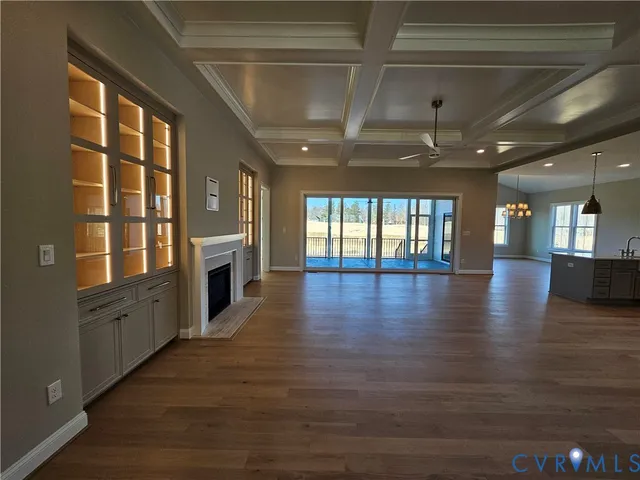 a view of a hall with wooden floor and a kitchen