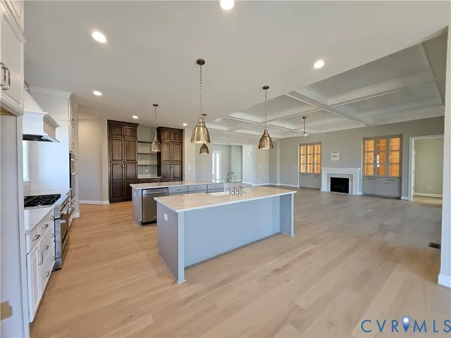 a large kitchen with granite countertop a large counter top stainless steel appliances and cabinets