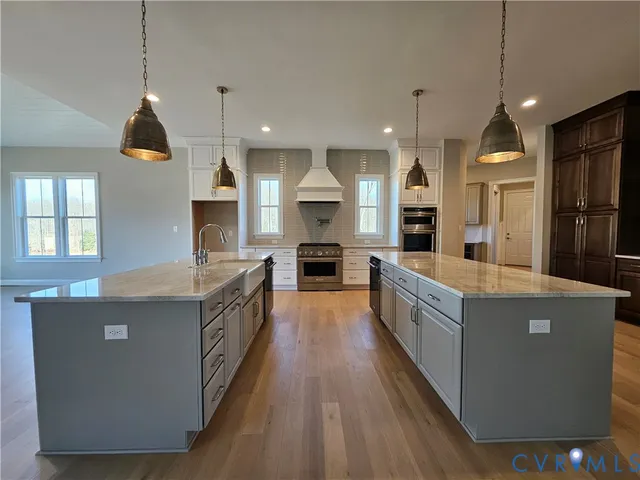 a large kitchen with kitchen island a large counter top space a sink stainless steel appliances and cabinets