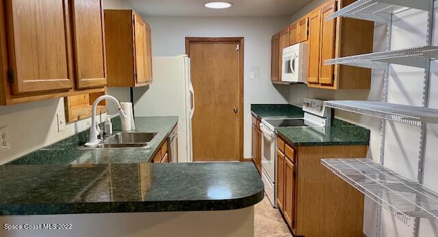 1309 Rascal Street Southeast Palm Bay, FL 32909 - Photo 8 of 17 a kitchen with kitchen island granite countertop a sink a stove and a microwave