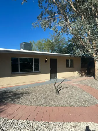 a view of a house with a yard and large tree