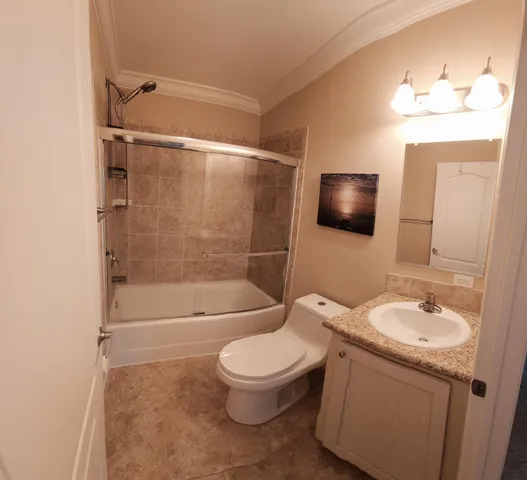 a bathroom with a granite countertop toilet sink and mirror