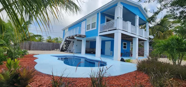 a view of a house with backyard and sitting area