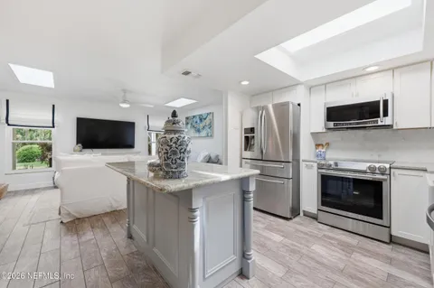 a kitchen with stainless steel appliances a refrigerator sink and microwave