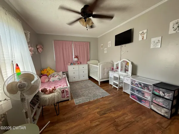 a bedroom with furniture and a flat screen tv