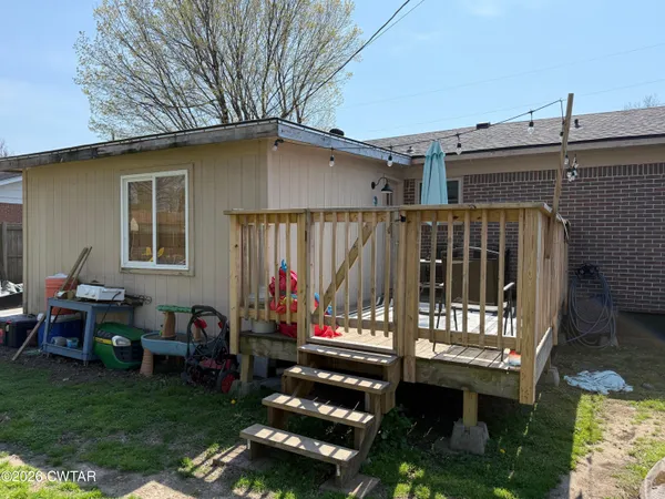 a view of a patio with a table chairs and a yard