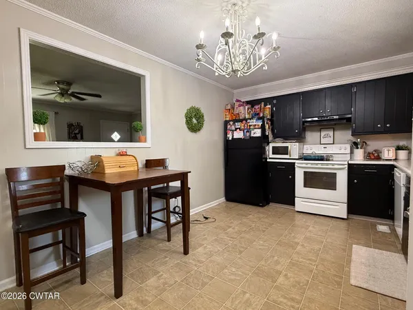 a kitchen with stainless steel appliances a table chairs and a refrigerator