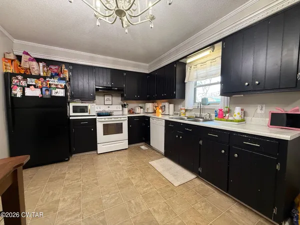 a kitchen with stainless steel appliances granite countertop a sink window and cabinets