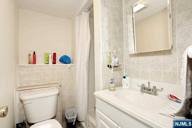 84 12th Street Cresskill, NJ 07626 - Photo 37 of 45 a bathroom with a sink a toilet and a shower curtain