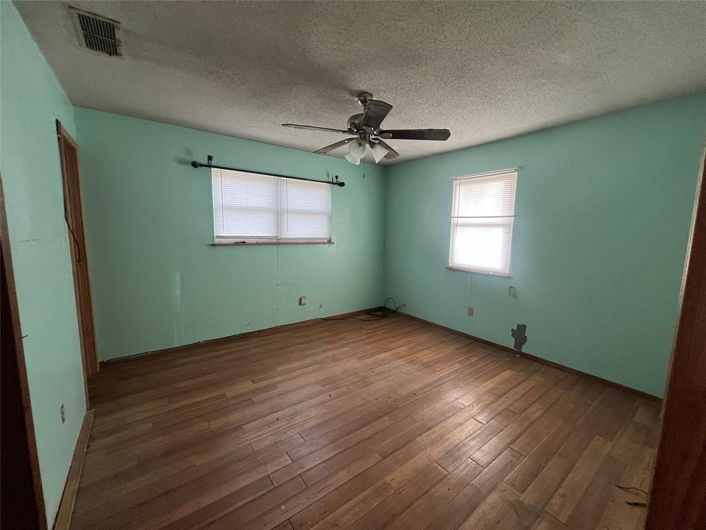 1335 Washburn Road North Bells, TX 75414 - Photo 5 of 12 a view of an empty room with wooden floor and a window
