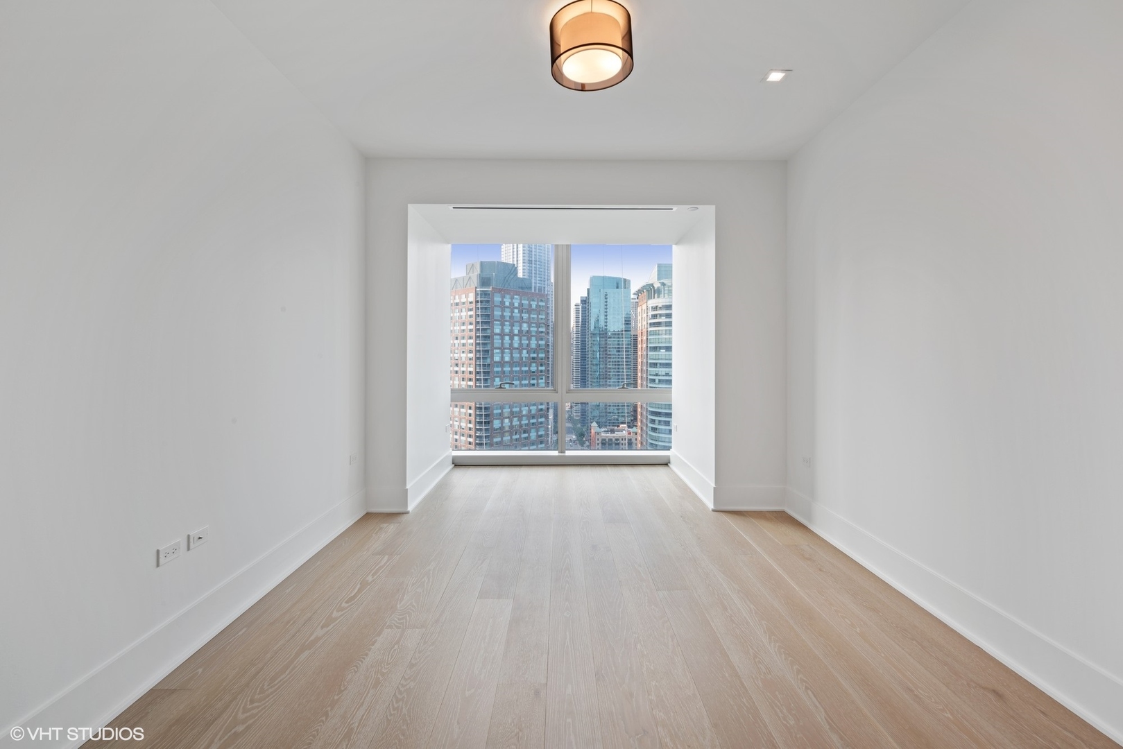 363 East Wacker Drive, Unit 1802 Chicago, IL 60601 - Photo 11 of 15 an empty room with wooden floor and windows