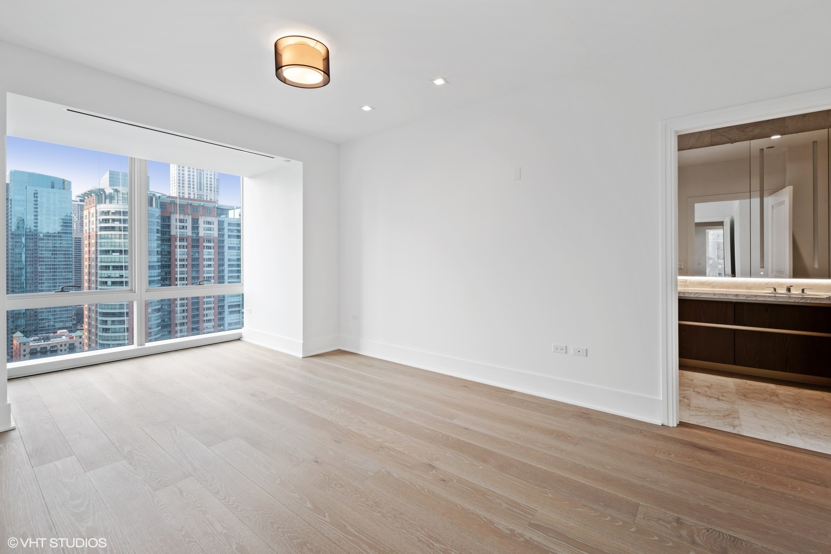 363 East Wacker Drive, Unit 1802 Chicago, IL 60601 - Photo 10 of 15 a view of an empty room with a window and wooden floor