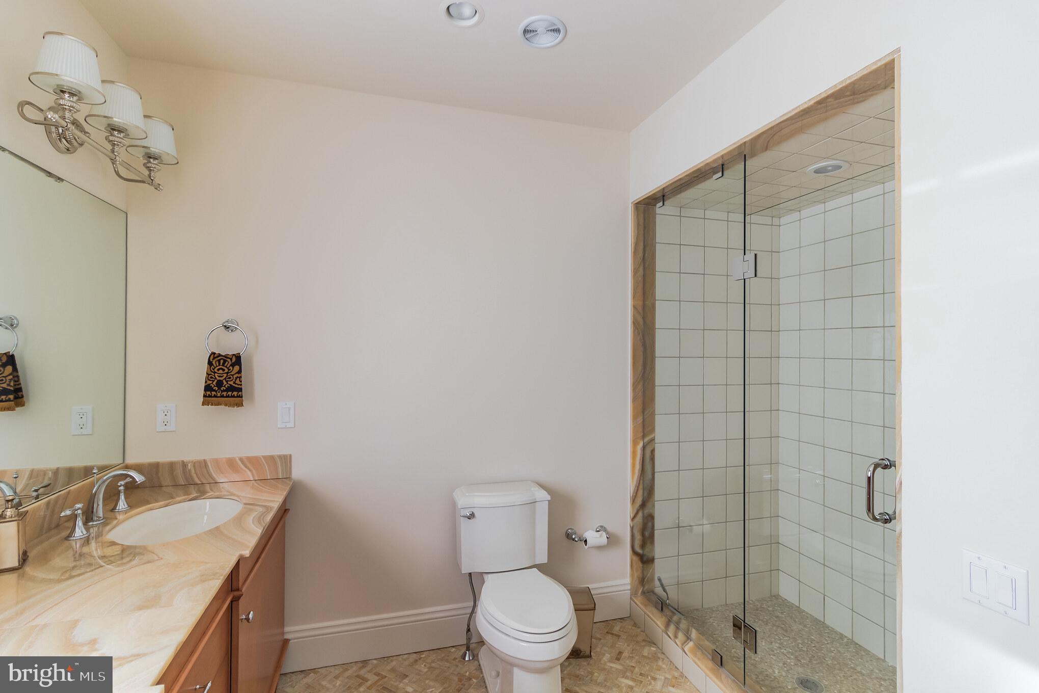 1911 Stone Ridge Lane Villanova, PA 19085 - Photo 25 of 32 a bathroom with a granite countertop sink a toilet and a mirror