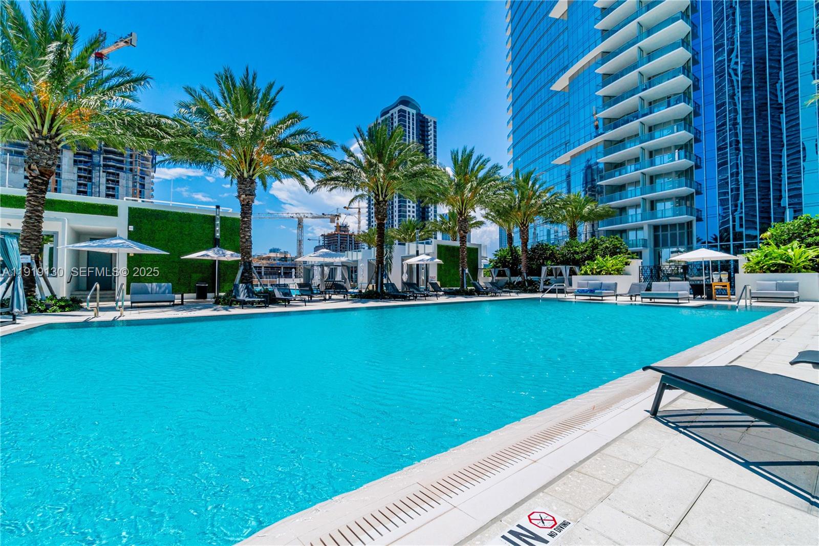 851 Northeast 1st Avenue, Unit 3511 Miami, FL 33132 - Photo 45 of 53 a view of a swimming pool with a table and chairs