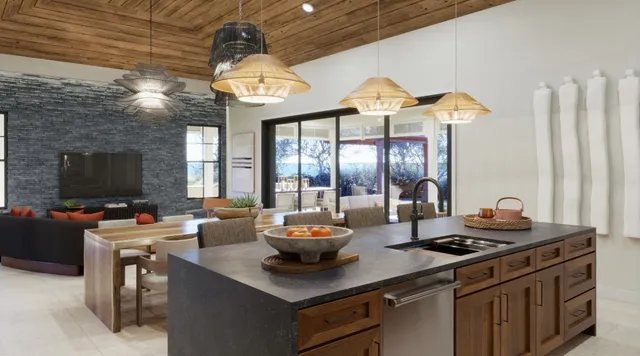 a kitchen with a stove a sink dishwasher and a dining table with granite countertops